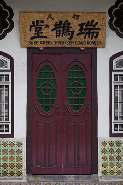 Traditional Chinese clan house entrance with vintage wooden doors and Nyonya tiles