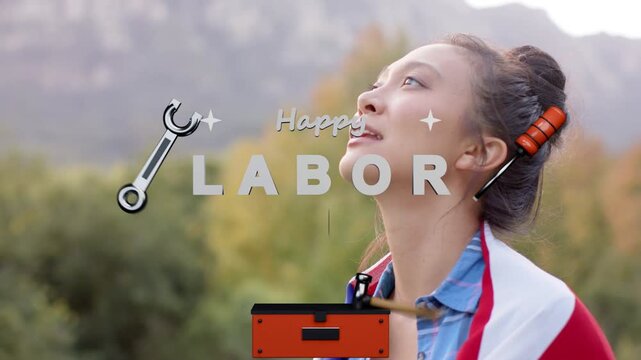 Woman standing smiling while toolbox drawer rising forming Happy LABOR DAY with tools covering face