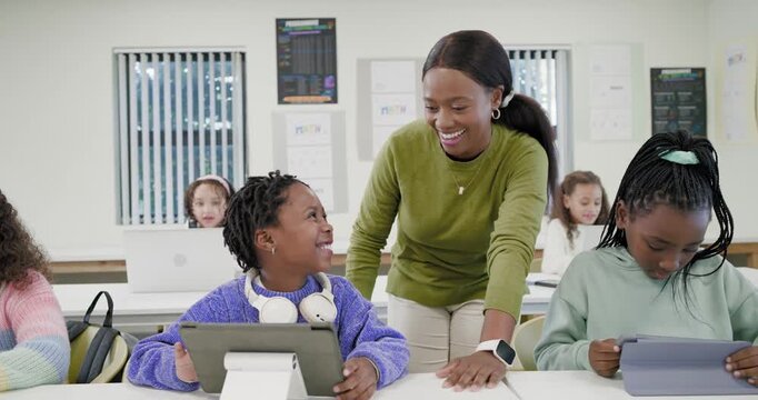 African-American woman teacher in green passing child, helping child tapping tablet on stand in lab