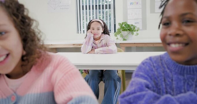 African American girls whispering in class, center girl watching folding arms lowering head on desk