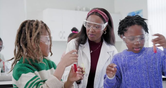 African American teacher guiding kids pouring test tubes after asking to compare colors at lab