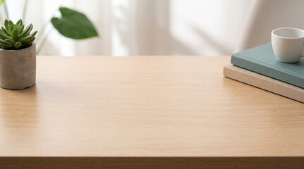 Fototapeta premium A clean, organized wooden table with open space, featuring a small potted succulent, two books, and a cup of coffee.