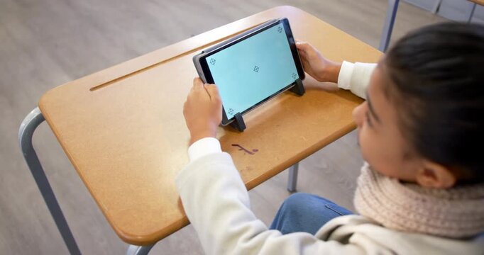 African American teen adjusting tablet on stand at school desk after calibration prompt, copy space