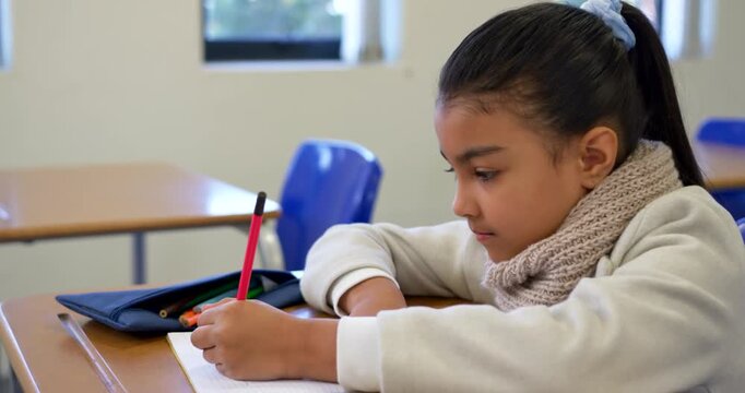 Schoolgirl writing red pencil at school, pausing, opening navy case, choosing green pencil to color
