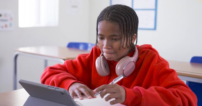 Tablet screen drawing focus, African American teen tapping and writing notes studying in class