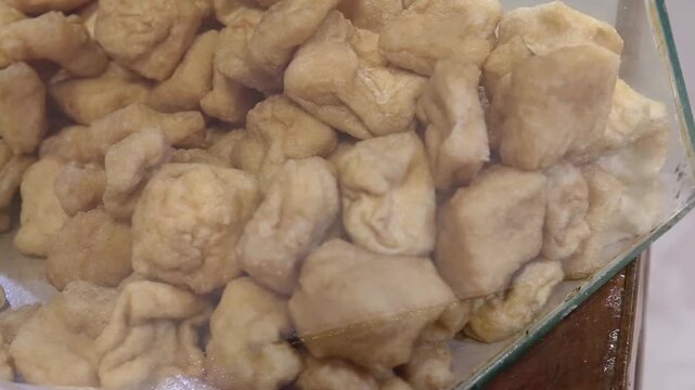 Fresh tahu gejrot displayed at street food stalls, featuring a crispy golden texture, authentic Asian cuisine, traditional snack ingredients, and ready-to-cook home-cooked meals.