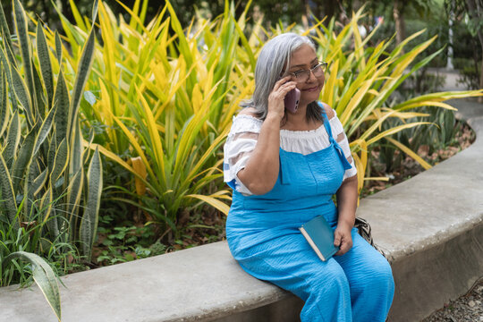 Elder woman calling with smartphone in park