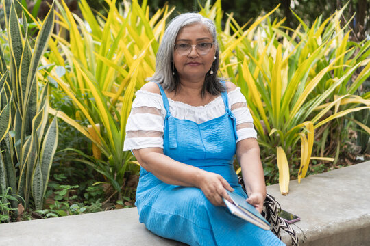 Older woman sitting in garden, enjoying nature and wisdom