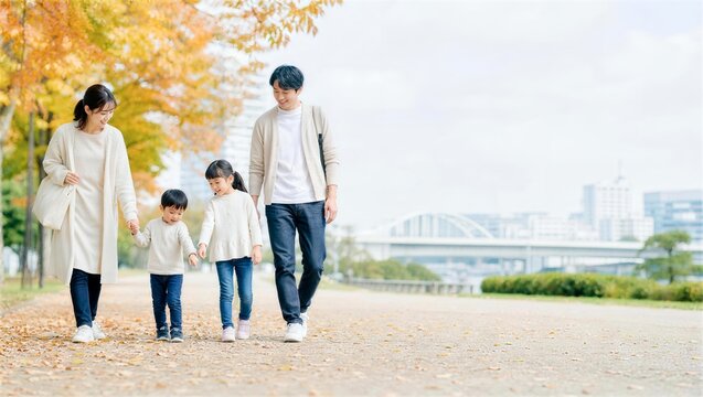 紅葉した川沿いを歩く四人の日本人家族