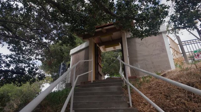 A stabilized camera move travels smoothly toward an entrance door within the hillside attraction grounds.