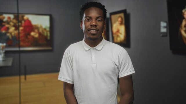 Man standing in art gallery beside renaissance painting with hands relaxed and face smiling; quiet admiration.