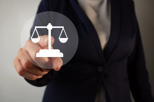 Businesswoman presses digital button with justice scale