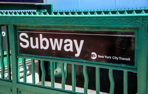 New York City, New York, USA, June 14th, 2026: A close-up shot of a classic green metal New York City Subway entrance railing, featuring the iconic black and white "Subway" sign with the MTA New York 