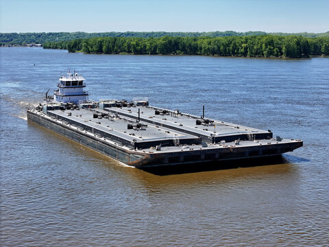 tugboat navigating North up the Mississippi river pushing a set of liquid cargo barges