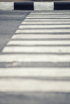 Abstract view of a pedestrian crossing with black and white stripes on asphalt