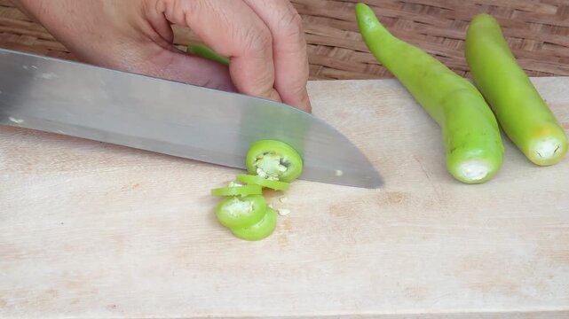 Slicing Chili Peppers on a Wooden Cutting Board