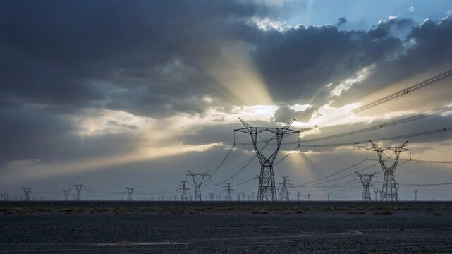 Time-lapse Of the High Voltage Transmission Towers in Gobi Desert with Dramatic Sunbeams Through Clouds at Dusk