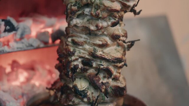 Vertical meat spit al pastor style with fresh onion. Tacos