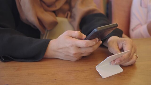 young woman using smart phone to scan the QR to find the cafe menu 