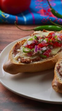 Delicious Mexican-style appetizer. Molletes with pico de gallo on top