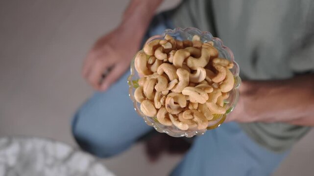 Holding a bowl of cashew nuts in hand