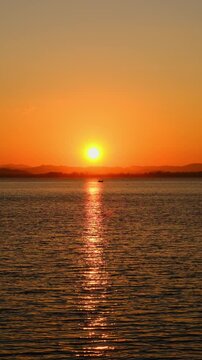 nature sky breathtaking golden sunset over a calm ocean, with the entire sky and water bathed in brilliant shades of yellow and orange. Streaky clouds enhance the dramatic display	