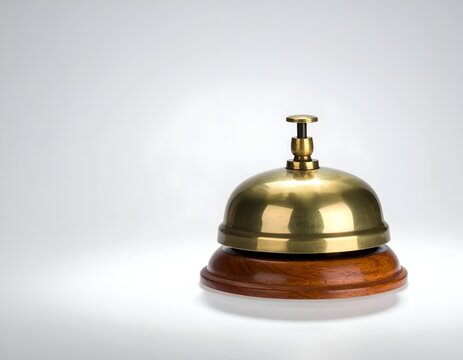 Brass Hotel Reception Bell on a Wooden Base Isolated on a White Background