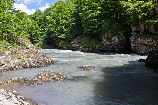 summer period - granite canyon of a mountain river, walking along a stone riverbed, rapid flow of water, close-up