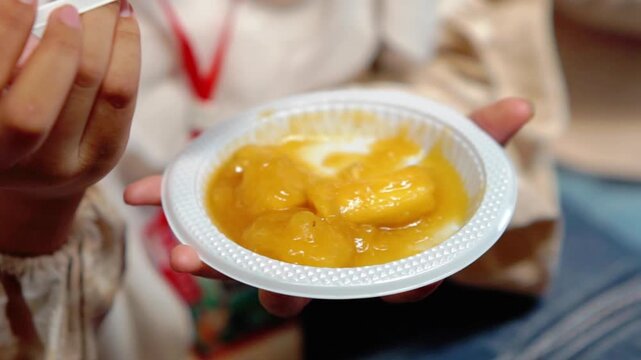 Enjoying cimplung, Indonesian food. Cimplung is a food typically made from cassava, breadfruit, or other tubers boiled with palm sugar until the mixture thickens.