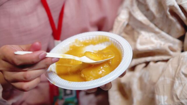 Enjoying cimplung, Indonesian food. Cimplung is a food typically made from cassava, breadfruit, or other tubers boiled with palm sugar until the mixture thickens.