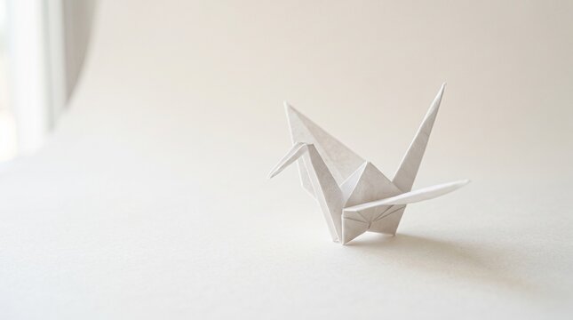 Origami paper crane on plain surface