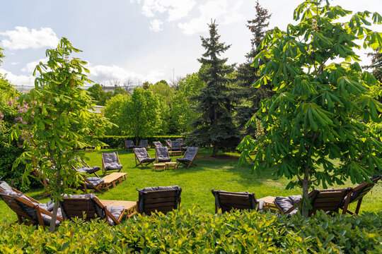 Outdoor lounge chairs arranged on green lawn