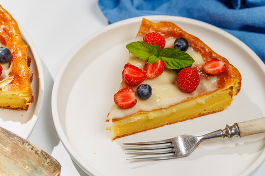 Slice of berry tart served on plate beside whole pie
