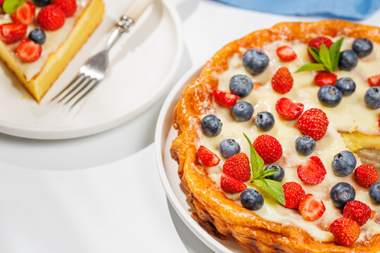 Slice of berry tart served on plate beside whole pie