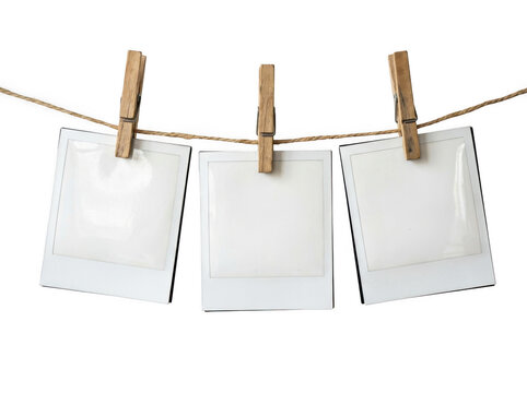 Three blank instant photo frames hanging on a clothesline with wooden pegs