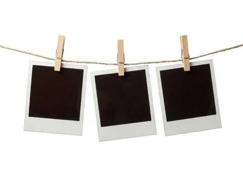 Three blank instant photo frames hanging on a rope with wooden clips