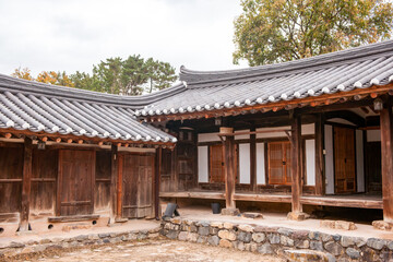 Fototapeta premium Traditional Korean Hanok Courtyard and Wooden Buildings Featuring Tiled Roofs, Eaves, and Stone Foundation