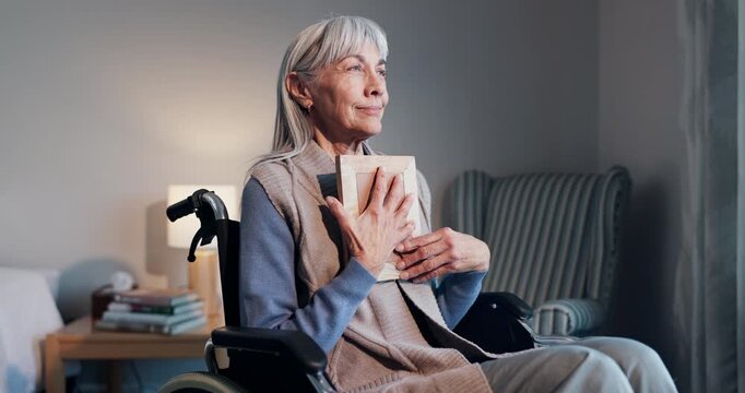 Senior, woman or wheelchair with picture frame in home for past memory, loss or mourning. Elderly, hug or female person with a disability, photograph or moment of silence for grief or love in house