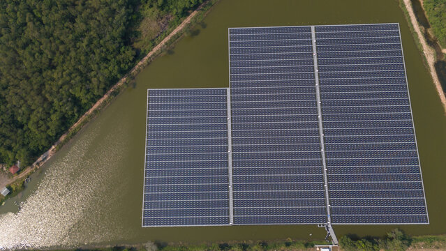 An aerial view shows workers cleaning solar panels in a large body of water.
