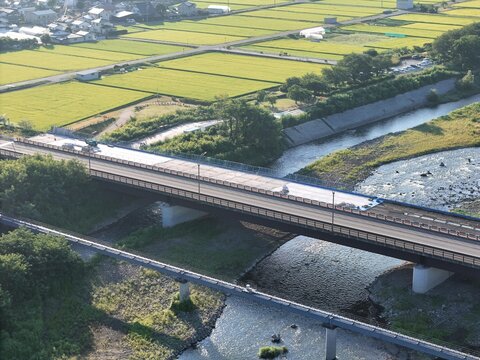 Bridge spans river, connecting green fields and rural lanes