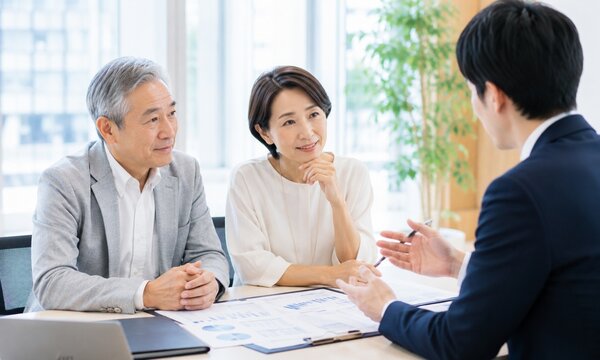 保険や資産運用について相談するシニア夫婦とファイナンシャルプランナー
