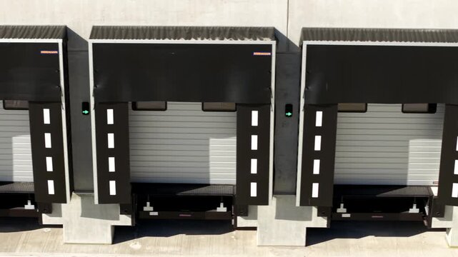 High angle close up aerial view focusing on the industrial loading bay doors and docking stations at a large commercial distribution centre, UK.