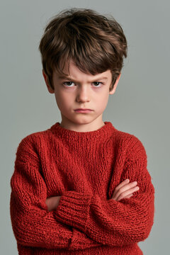 angry boy in staring with folded arms on isolated on plain gray colour studio background