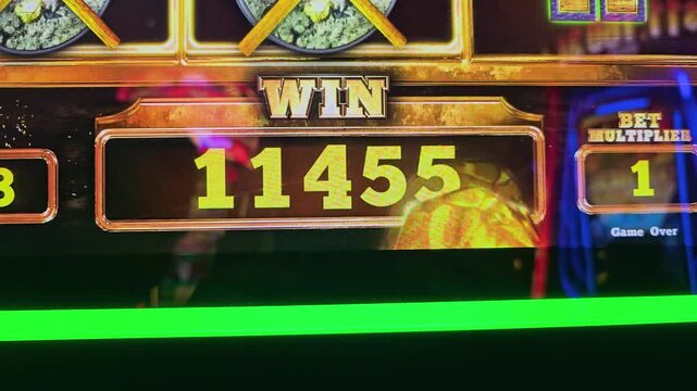 Close view of a slot machine payout screen with bold credit numbers, gold trim, colorful reflections, and flashing casino lights for gaming, jackpot, and entertainment videos.