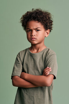 angry POC boy confused with folded arms on isolated on plain green colour studio background