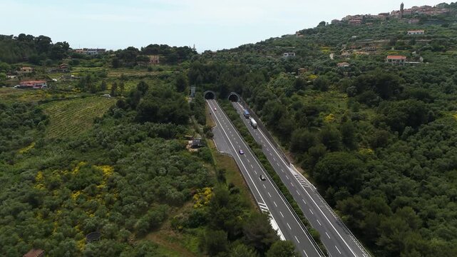Drone shot of trucks driving on the A10 E80 motorway in Liguria, summer in Italy