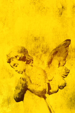 Angel cherub figure praying on a grunge gold background backdrop. Religious christian concept.