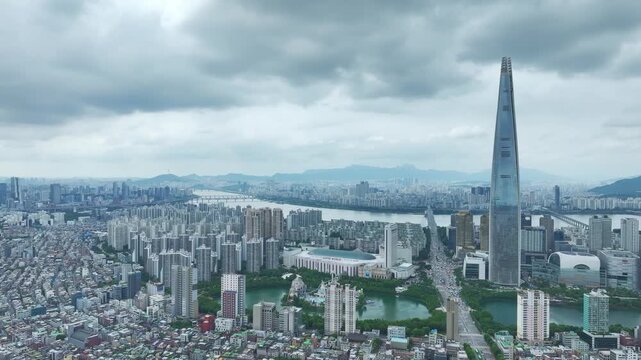 Aerial Drone View of Jamsil Station Cityscape, Lotte World Tower, and Han River Landscape in Seoul, South Korea