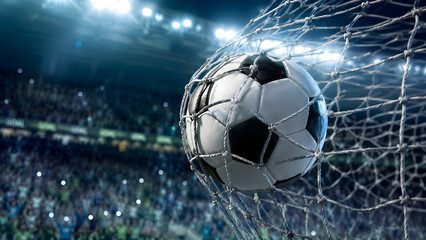 Fototapeta premium Classic soccer ball hitting the net in goal during an intense football match at packed stadium arena