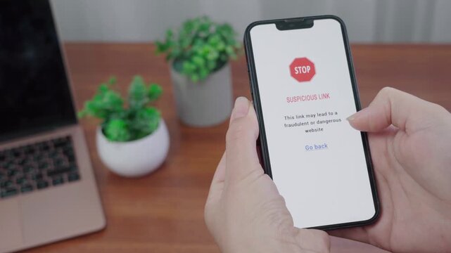 AI information app displays a suspicious link STOP warning on a mobile screen as a thumb hovers near the go back option.